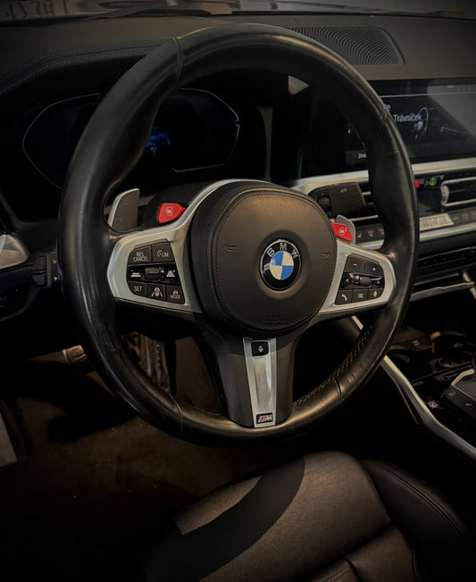 Steering wheel of a BMW car with logo in the center.